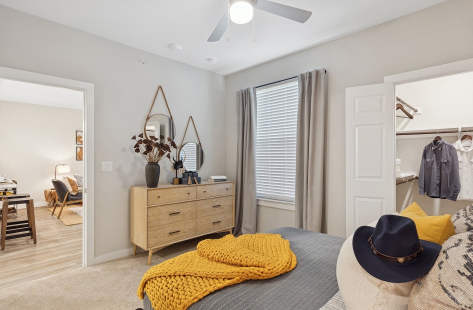 a bedroom with a dresser and mirrors