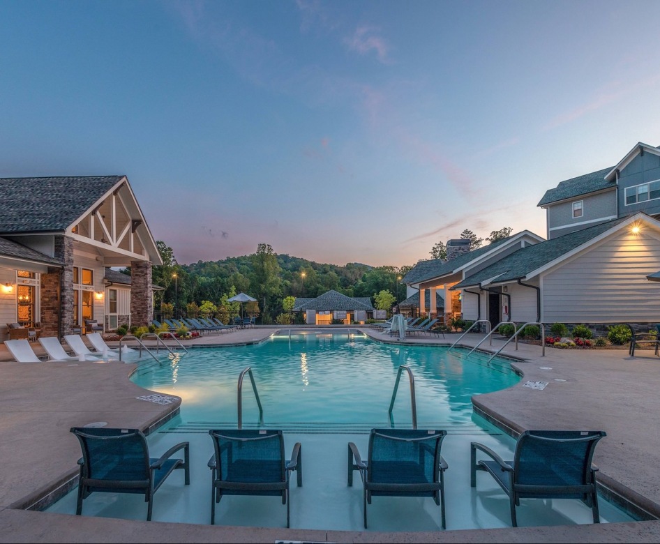a pool at dusk with seating