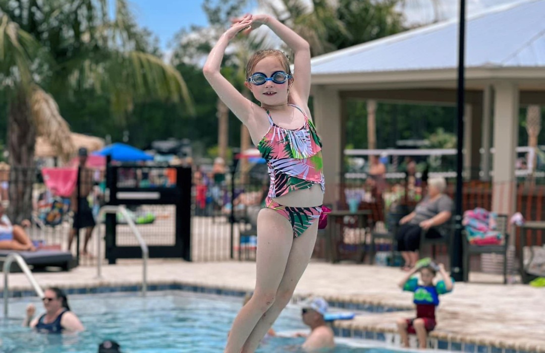 a someone lifting up a girl in a pool