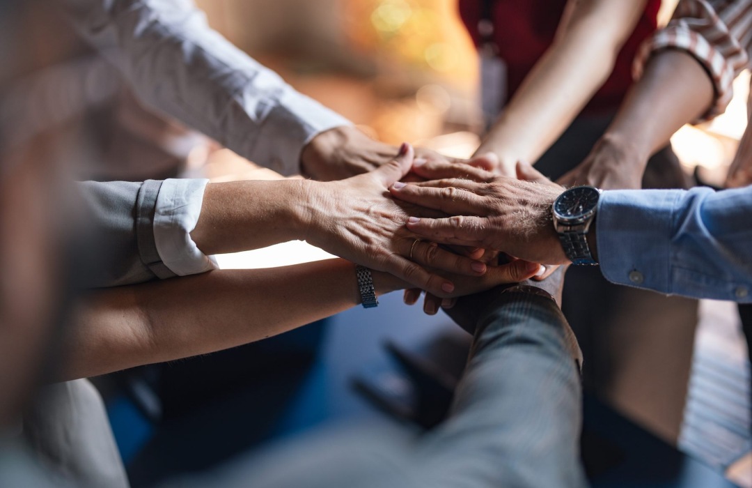 people putting their hands together in a circle